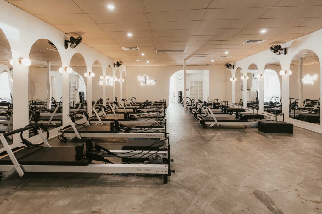 Pilates reformers, hardwood floors and welcoming reception area for this fitness fit out for Hello Pilates