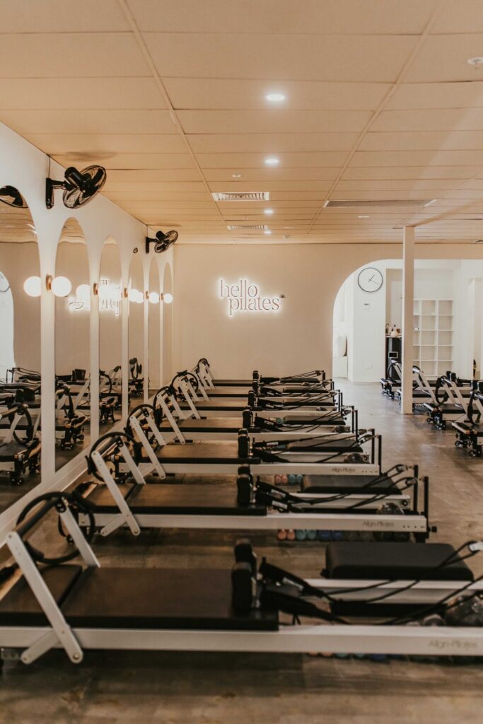 Light colour palette, high end reformer beds and curved doorways and mirrors for this fitness fit out for Hello Pilates