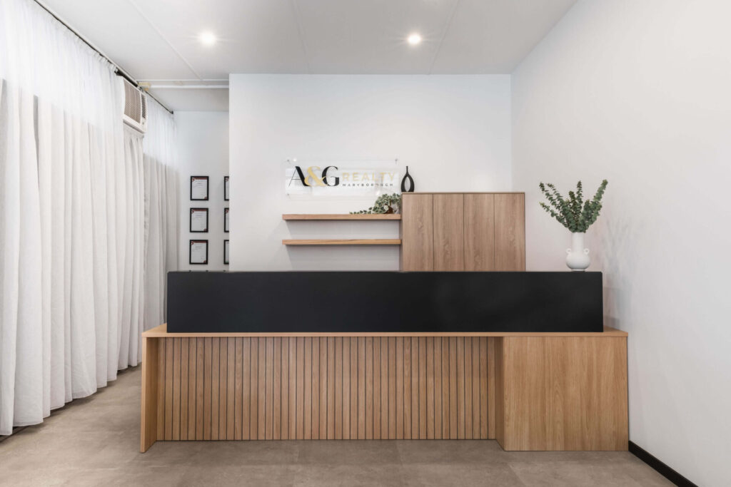 Sheer linen curtains, stone tile flooring and inviting reception area for this office fit out for A&G Realty, Total Fitouts Wide Bay